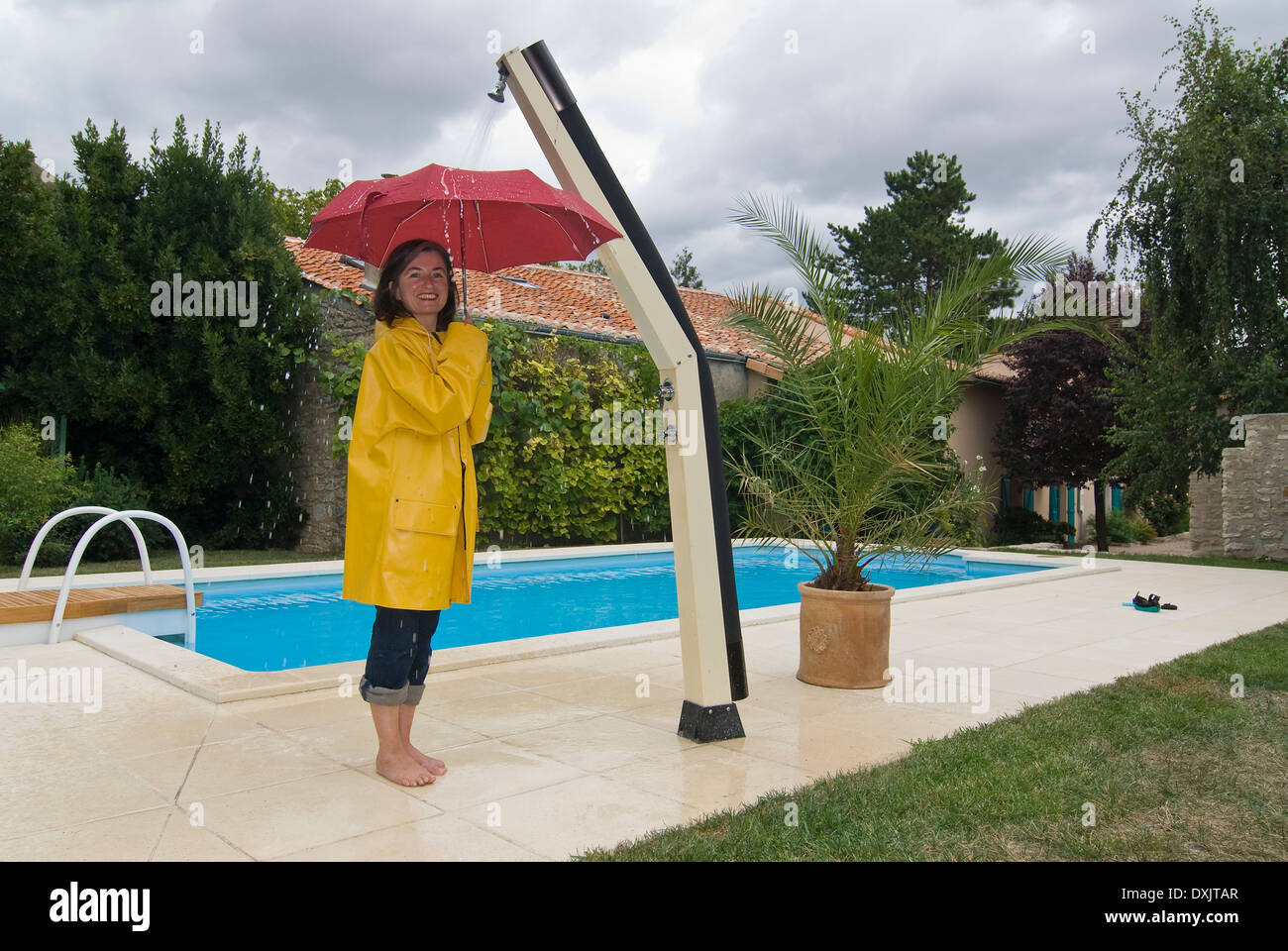 Frau mit Unbrella Außendusche Stockfoto