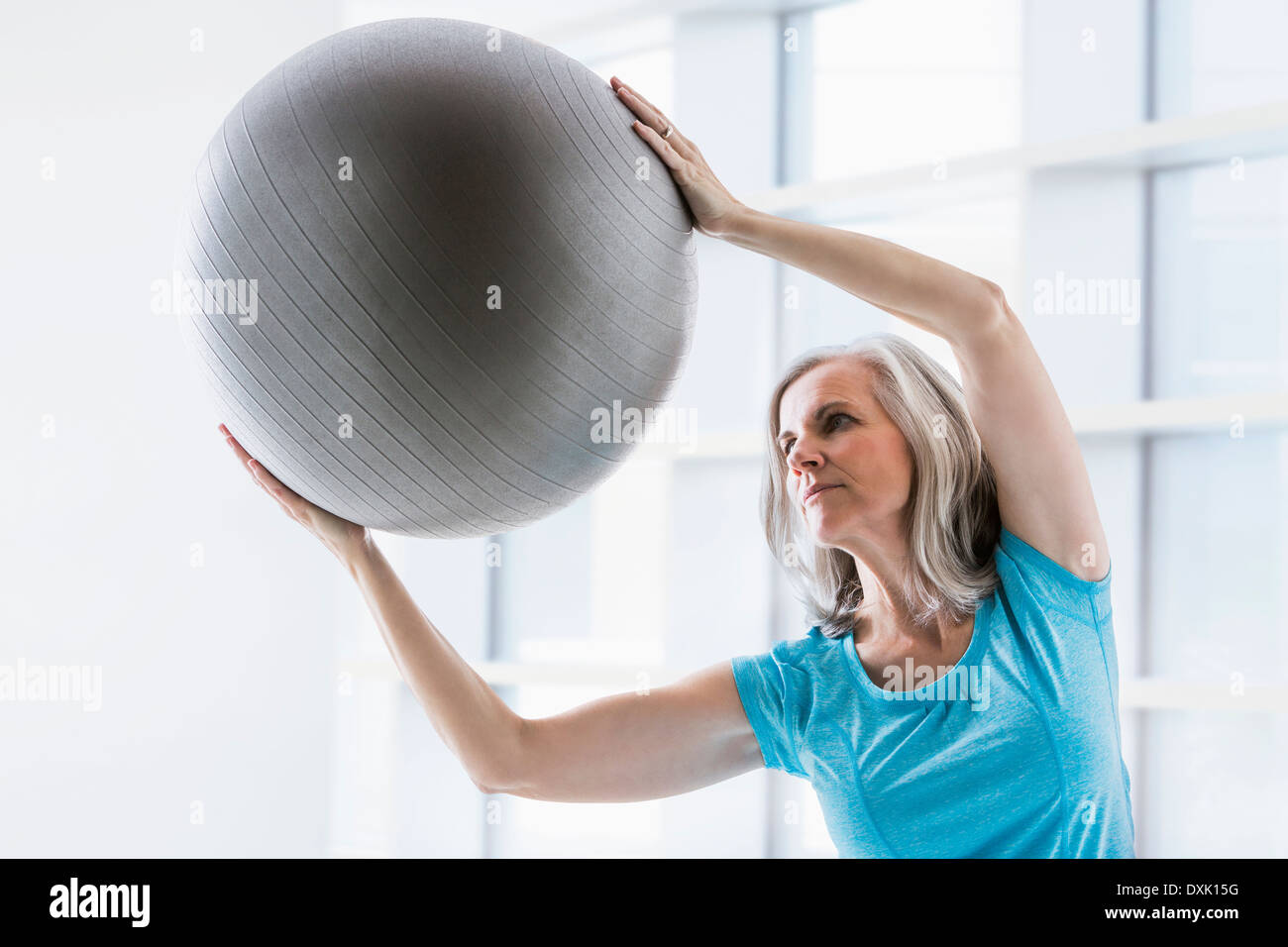 Kaukasische Frau lehnt sich mit Fitness-ball Stockfoto
