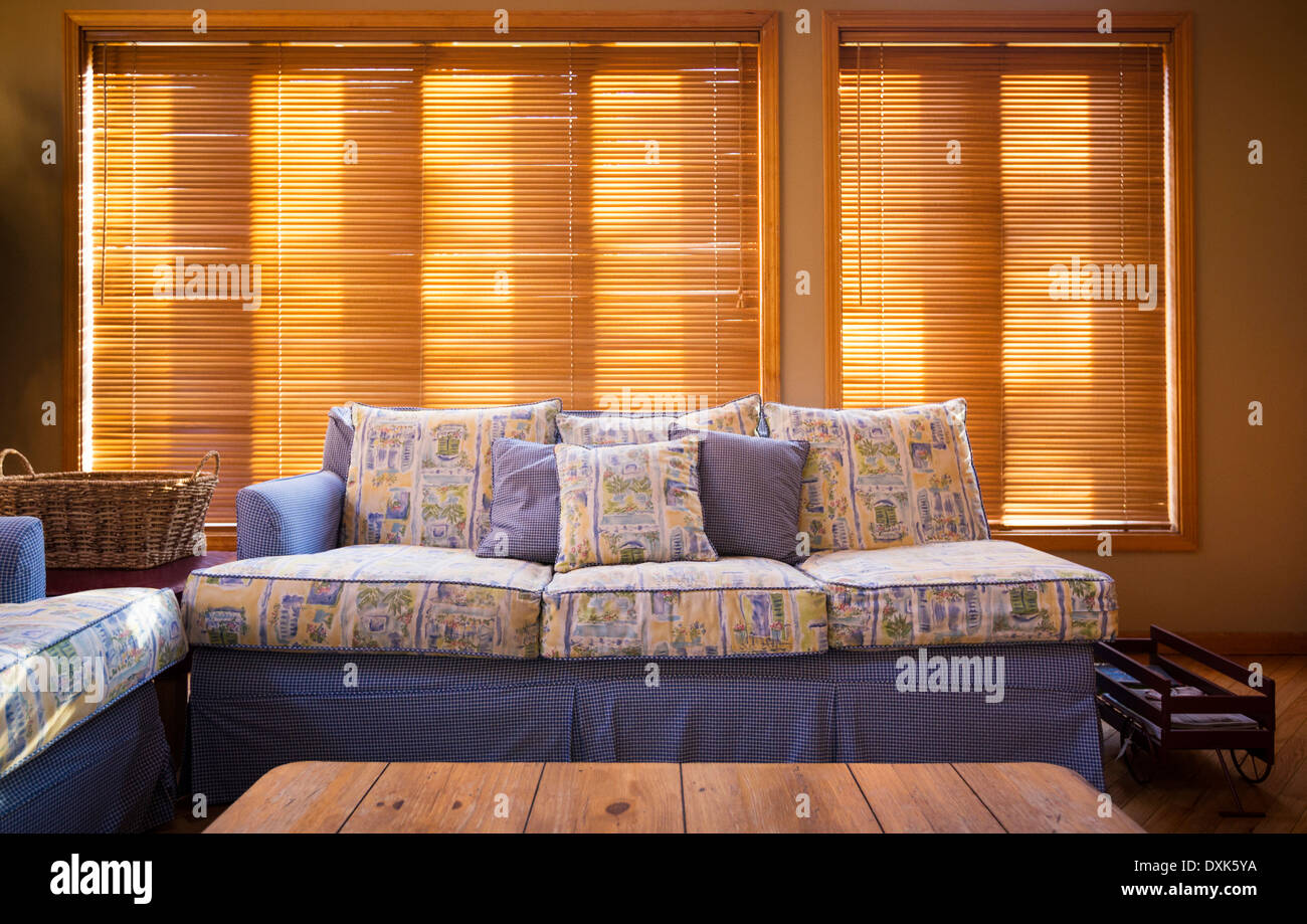 Holz Jalousien hinter Sofa im Wohnzimmer Stockfoto