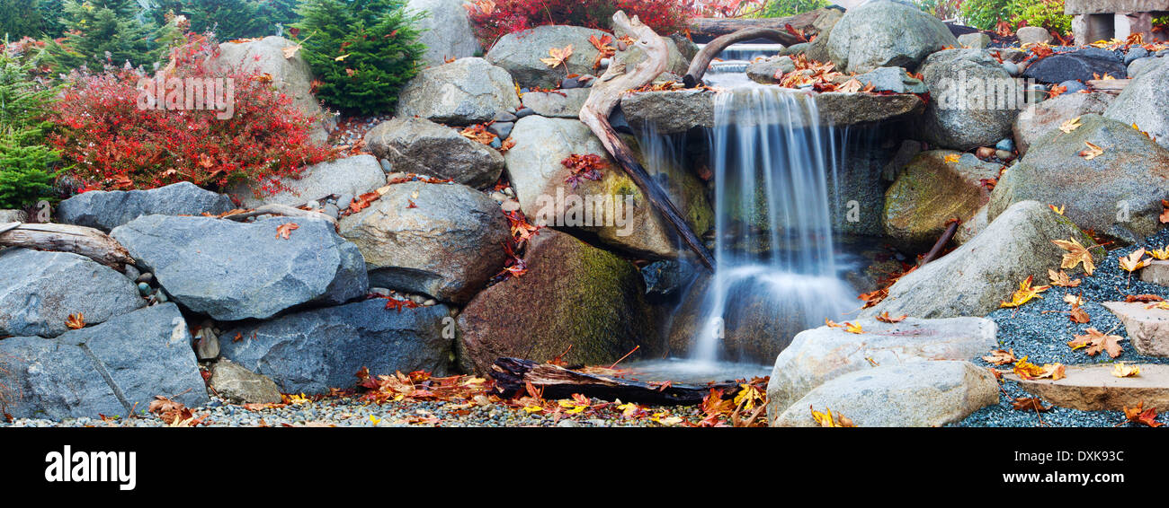Herbstliches Laub rund um Wasserfall Stockfoto
