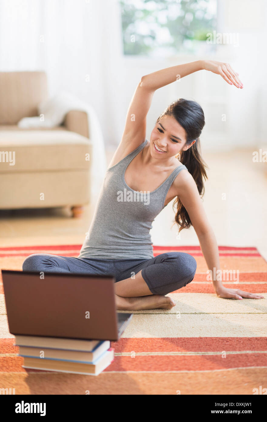 Hispanic Frau auf Teppich vor laptop Stockfoto