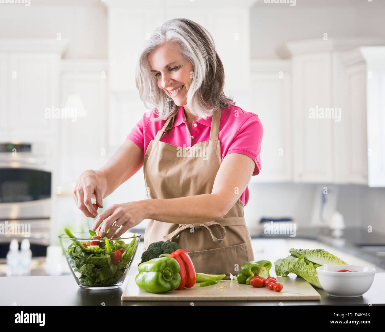 Kaukasische Frau bereitet Salat in Küche Stockfoto