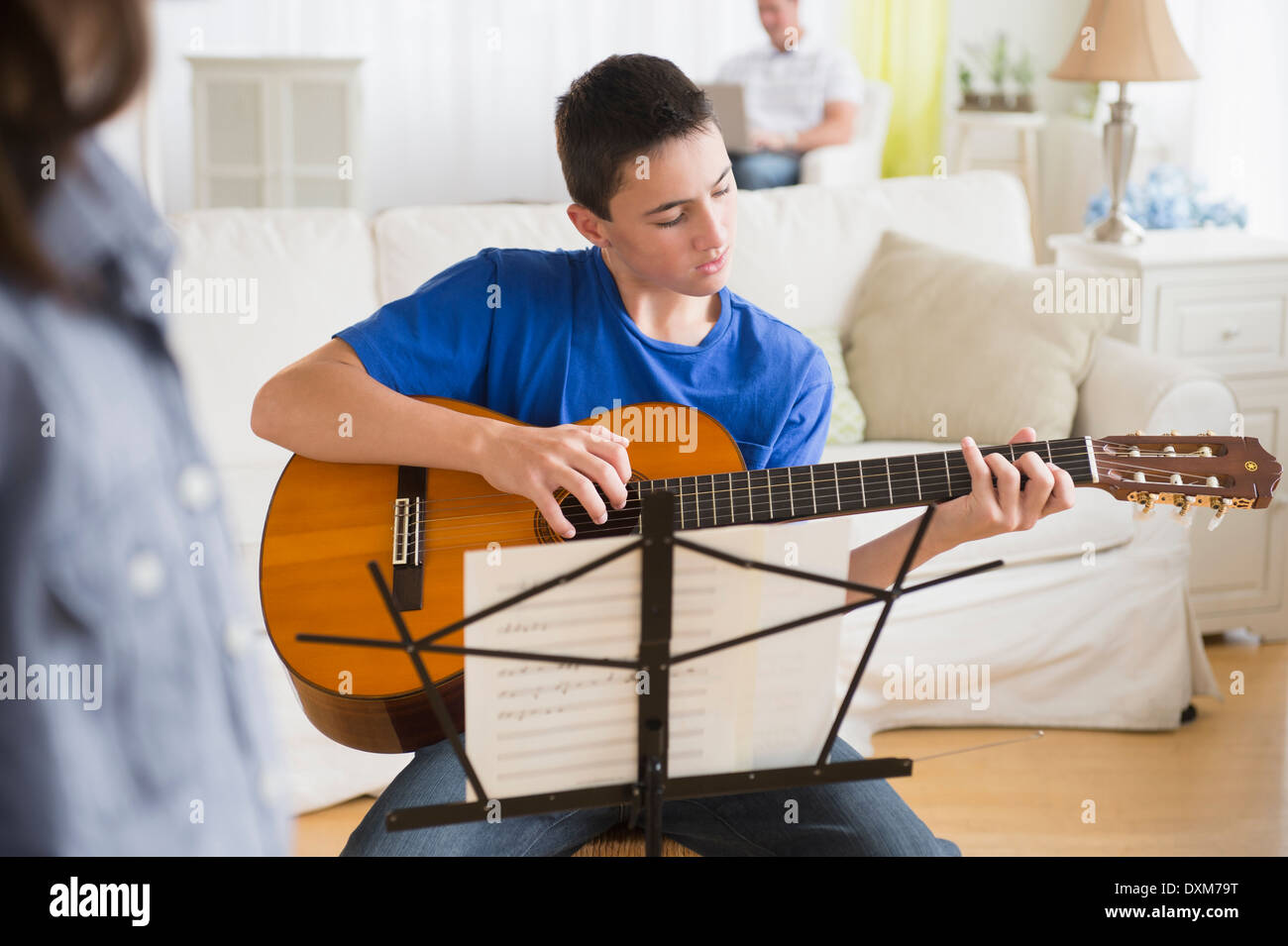 Kaukasische junge Gitarre im Wohnzimmer üben Stockfoto