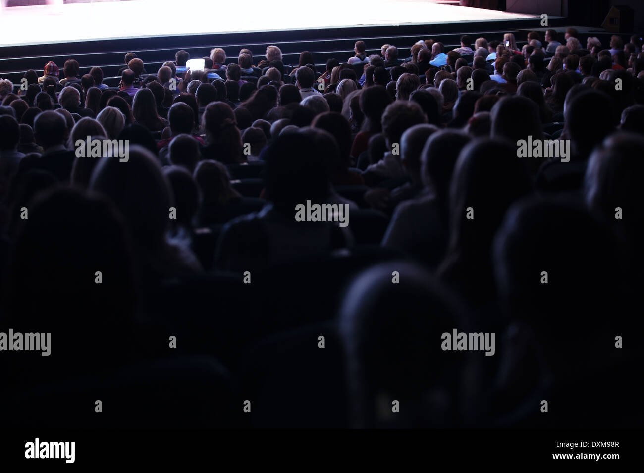 Blick von der Rückseite eines voll besetzten Auditorium oder Theater mit Sitzplätze in einem Zuschauer eine live-Performance auf der Bühne Stockfoto