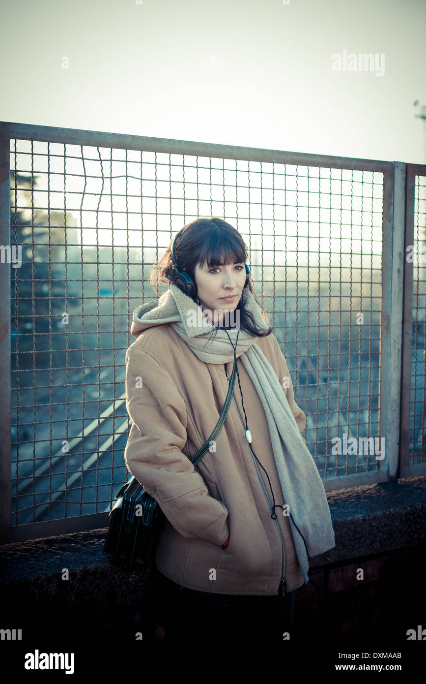schöne junge Frau, hören Musik Kopfhörer in der Stadt-winter Stockfoto