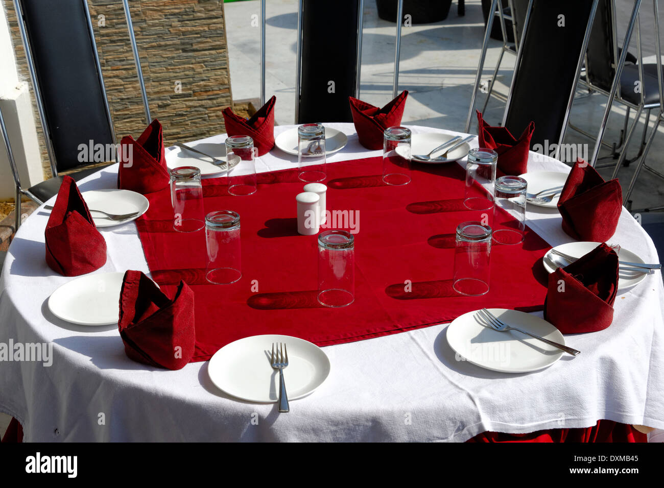Tisch, Gläser, Gabeln, Teller, Servietten auf rote und weiße Tischdecken Stockfoto