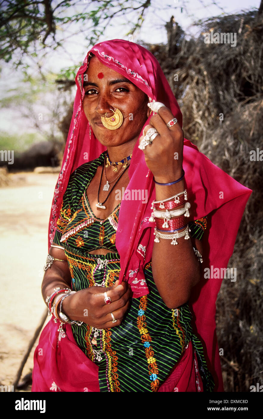 Indische Frau trägt Goldschmuck und rosa Kopftuch in einem Dorf in der Nähe von Jodhpur, Indien. Digital manipulierte Bild Stockfoto