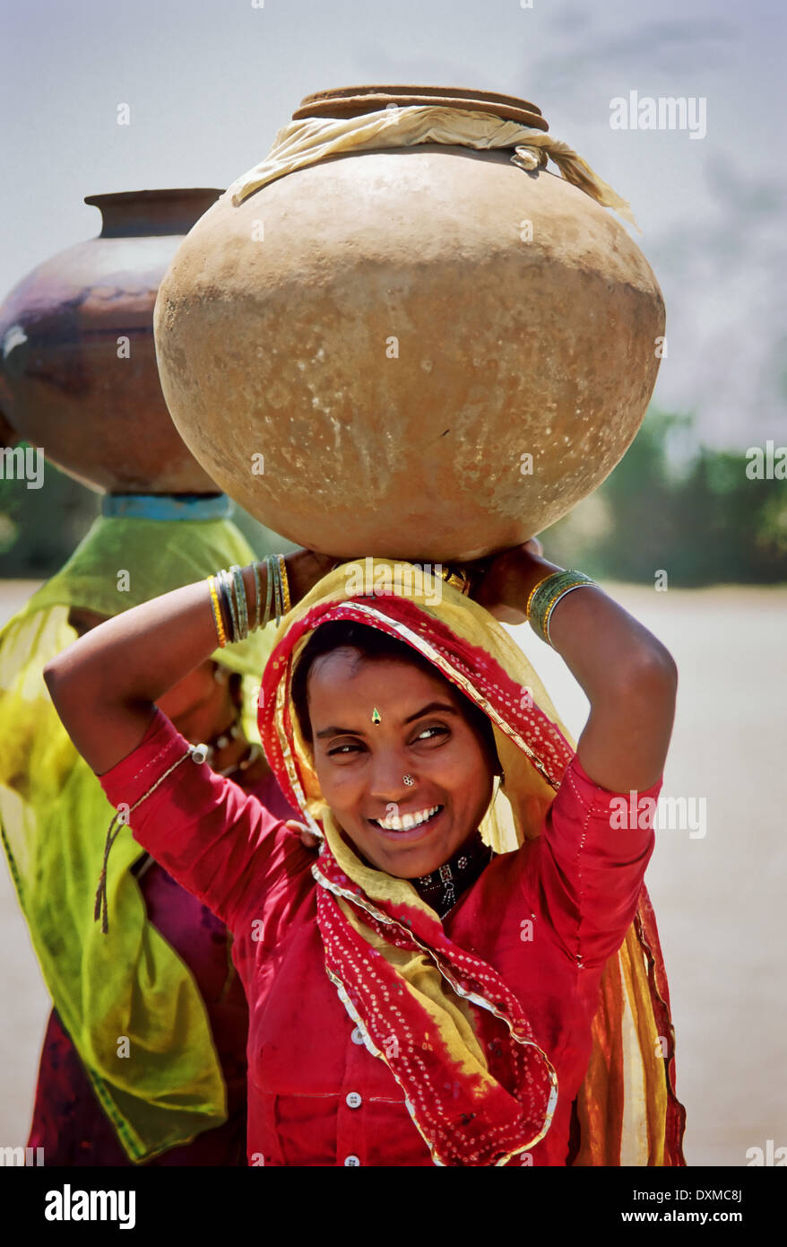 Indische Mädchen trägt einen Wasserkrug auf dem Kopf. In der Nähe von Jodhpur, Indien. Digital manipulierte Bild Stockfoto