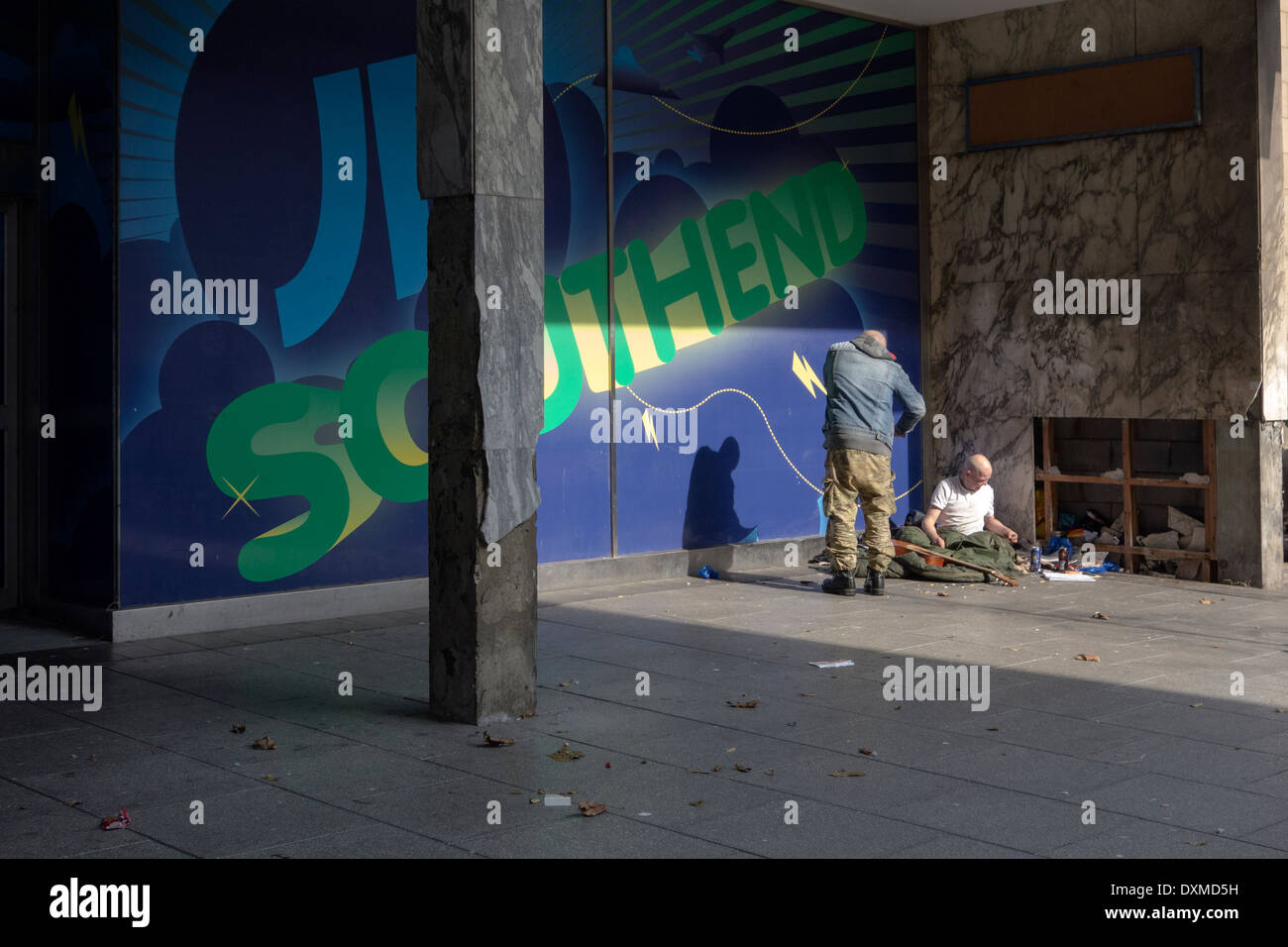 Zwei Obdachlose in einer ruhigen Ecke in der Nähe einer Hauptstraße. Stockfoto