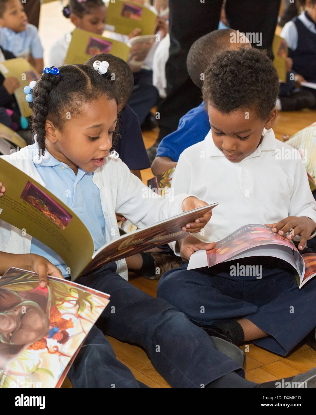 Kindergarten und Schüler der ersten Klasse an Chrysler Elementary School in Detroit lesen ein Buch. Stockfoto