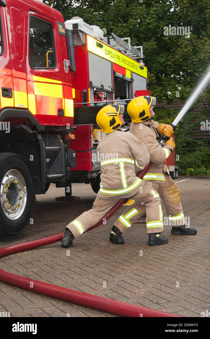 Zwei Feuerwehrleute zeigen Feuer Schlauch-Technik Stockfoto