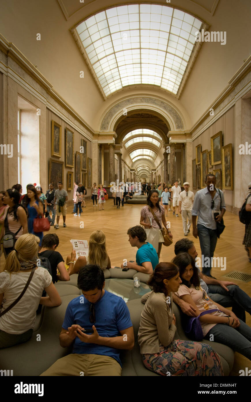 Besucher in den Louvre ausruhen unter berühmten Gemälden Stockfoto