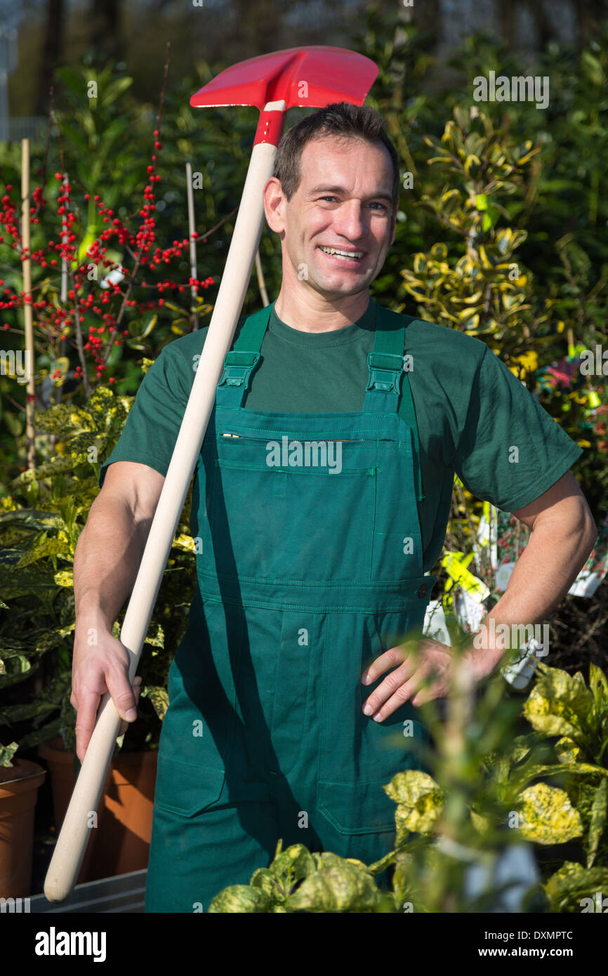 Landwirt oder Gärtner posiert mit Schaufel in Garten Baumschule