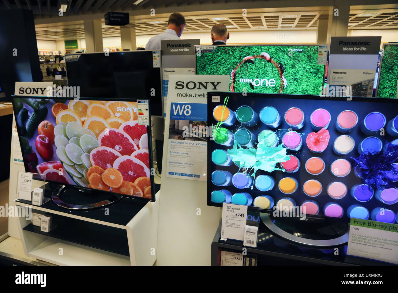 Kingston Upon Thames Surrey Mädchen Blick auf Sony und Panasonic-Fernseher In John Lewis Store Stockfoto