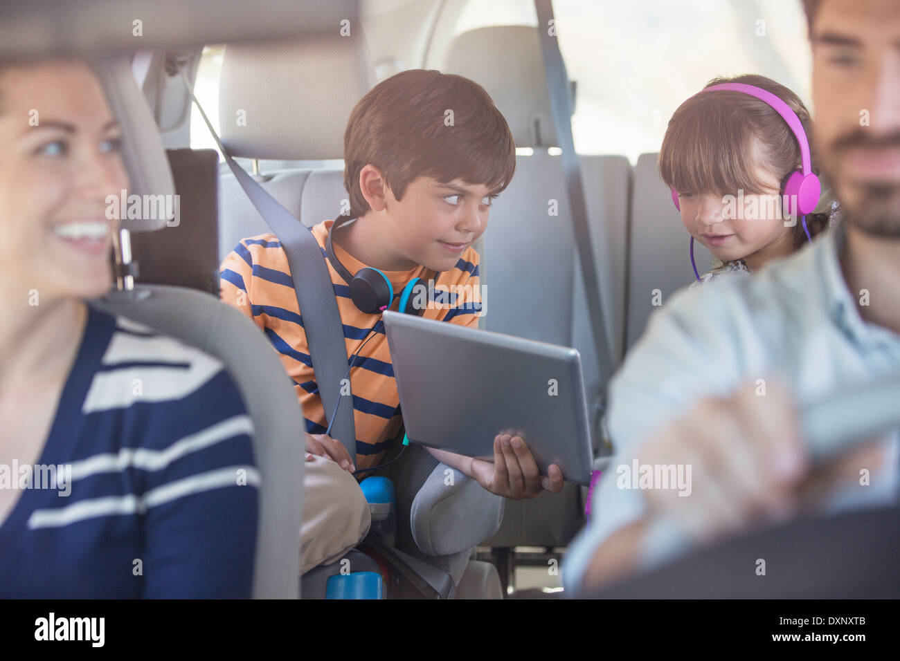 Bruder und Schwester teilen digital-Tablette auf Rücksitz des Autos Stockfoto