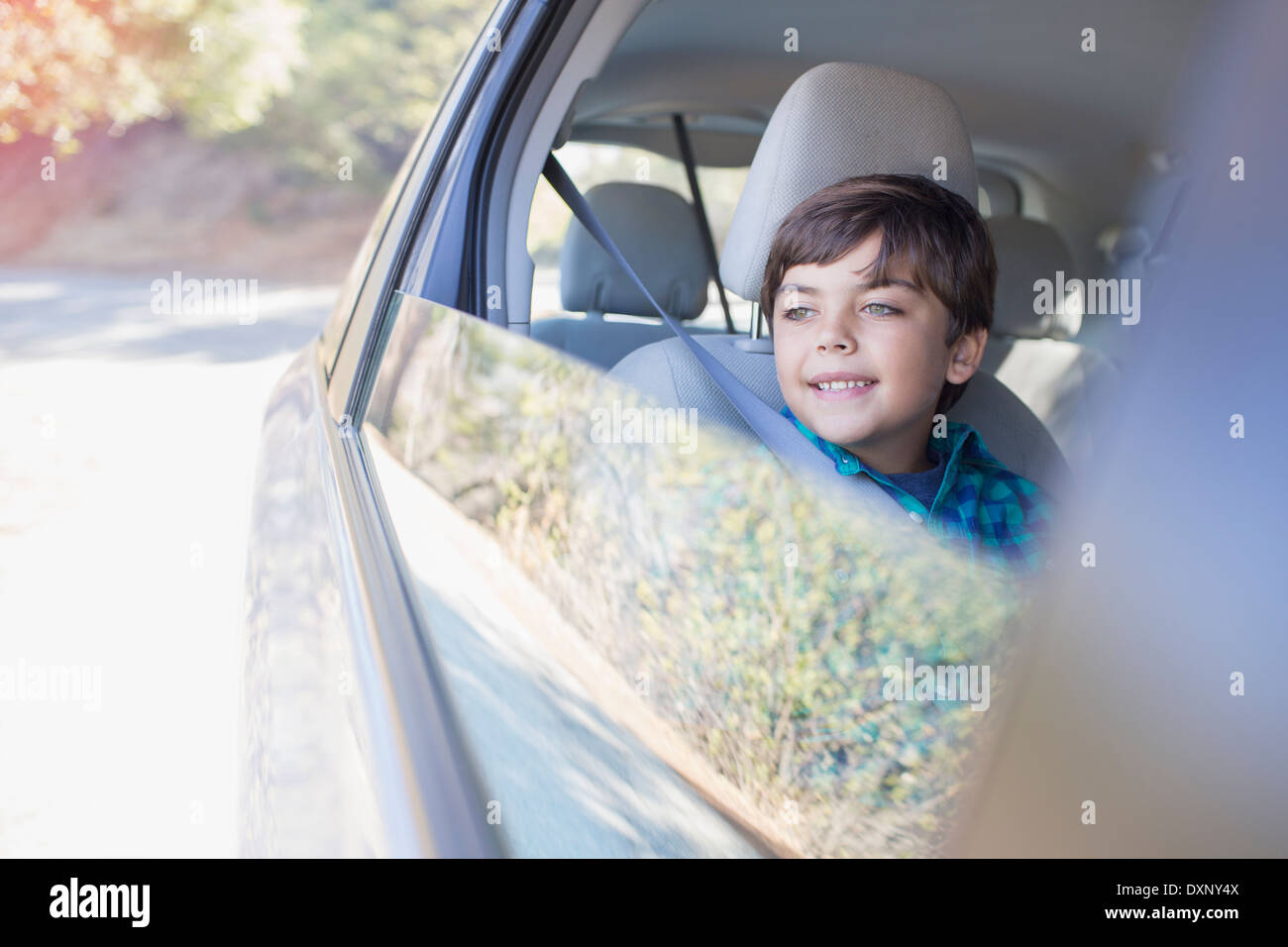 Fröhlicher Junge schaut aus dem Autofenster Stockfoto