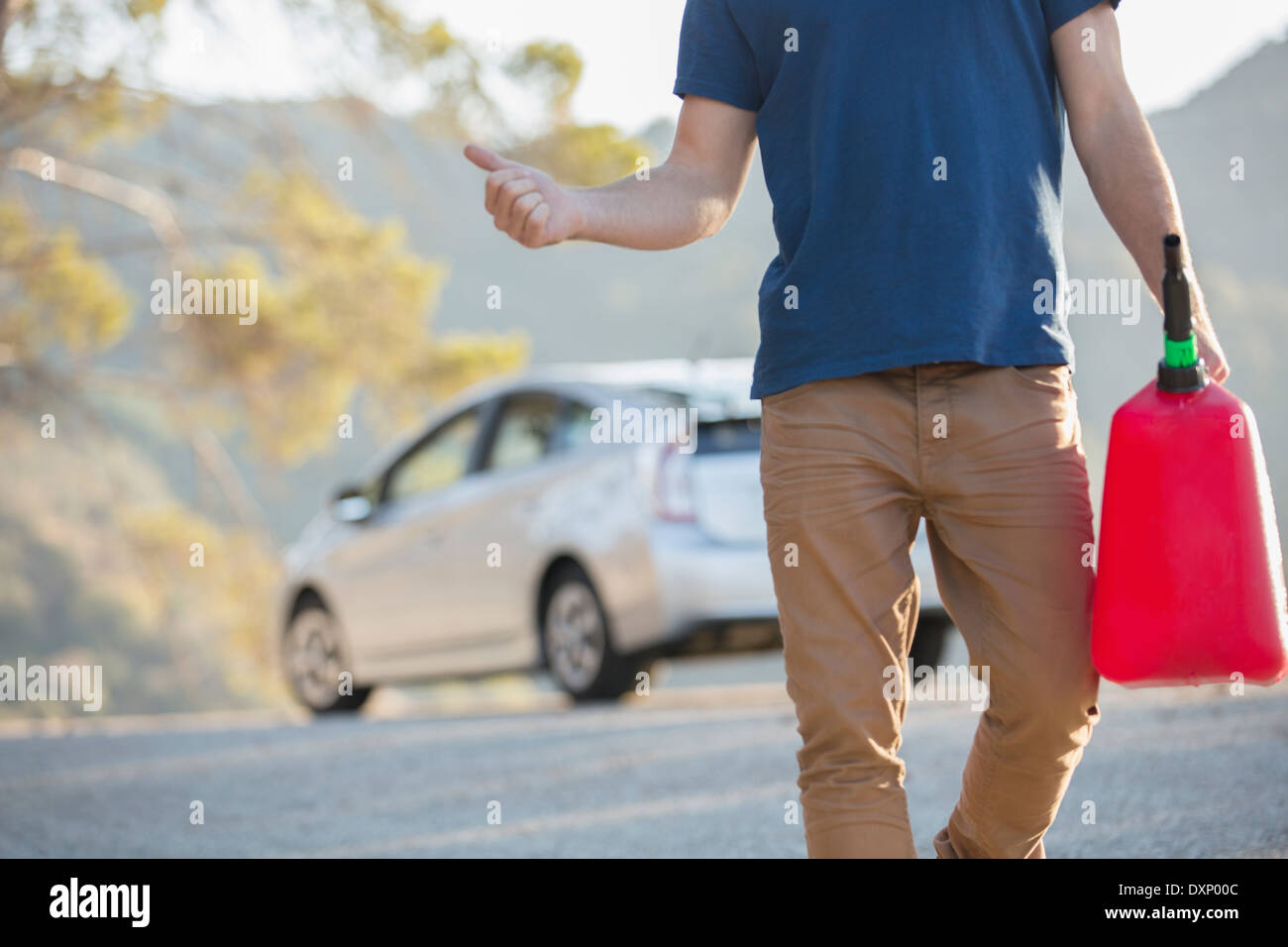 Mann mit Gas kann per Anhalter am Straßenrand Stockfoto