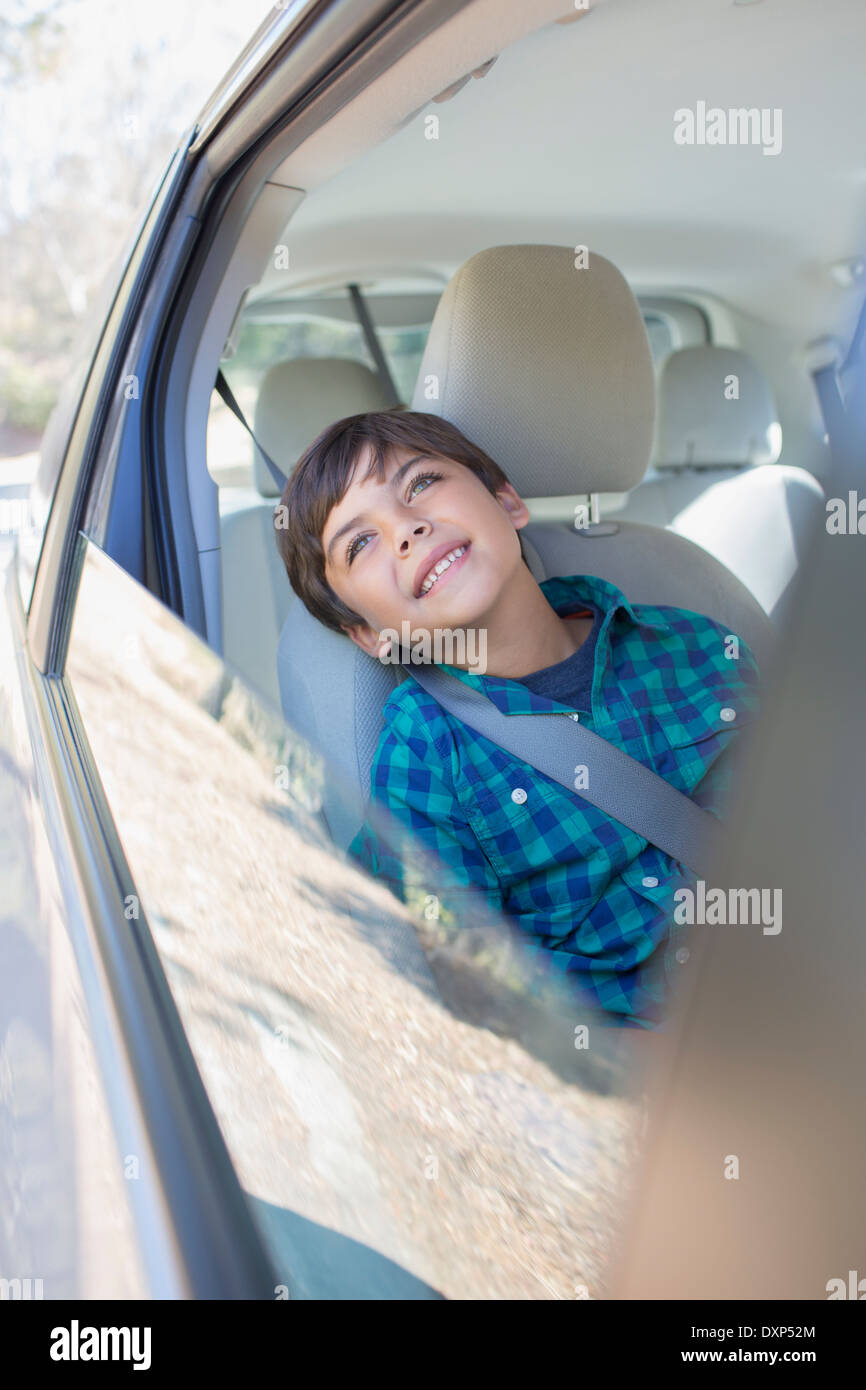 Fröhlicher Junge schaut aus dem Autofenster Stockfoto