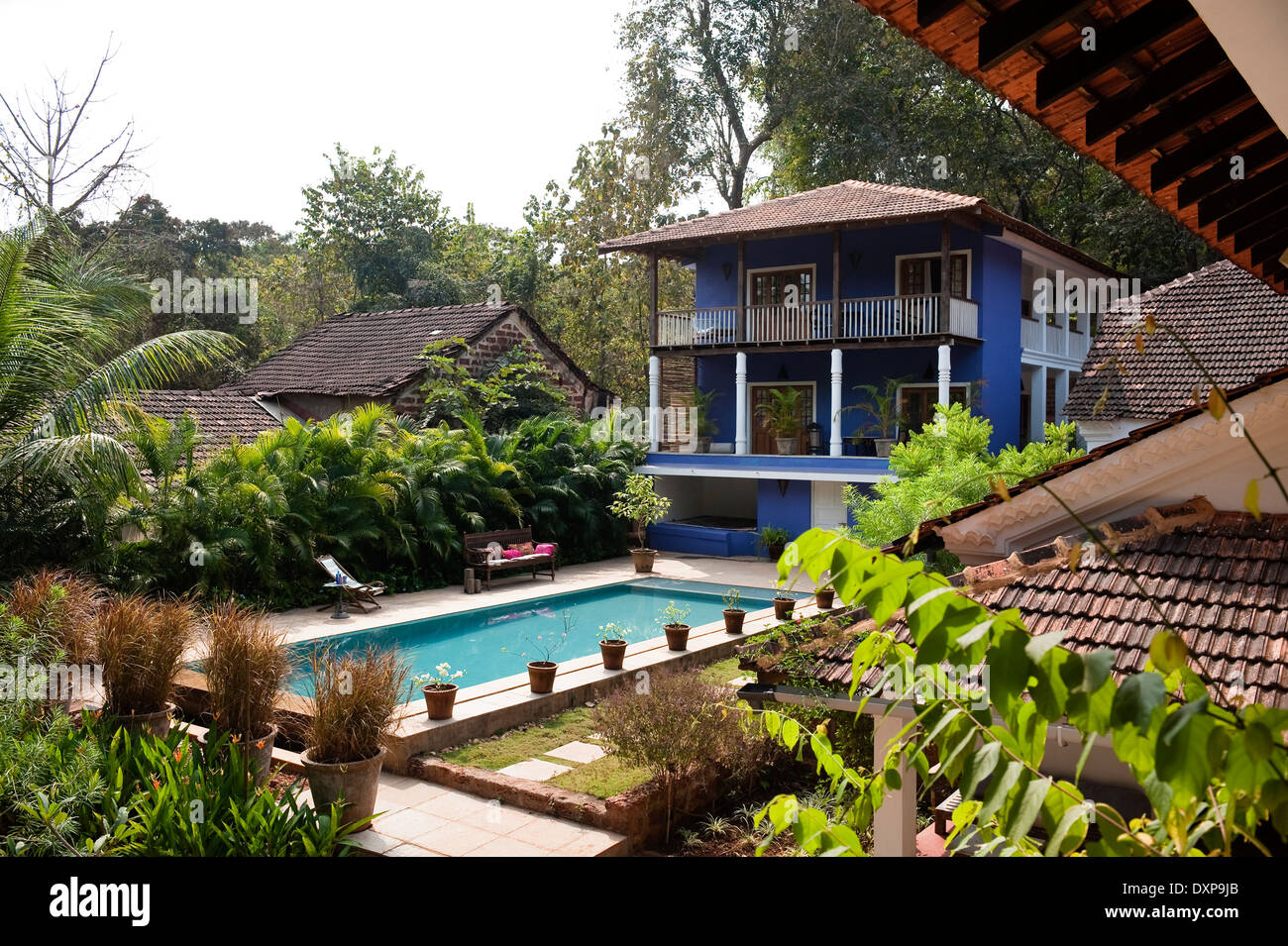 Blau gemalte Haus mit Balkonen mit Blick auf Swimmingpool im indischen Bundesstaat Goa Stockfoto