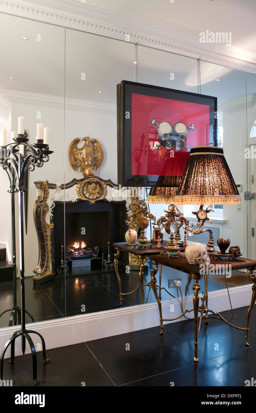 Trudi Tisch von Mark Brazier-Jones gegen Spiegelwand mit Reflexion der vergoldeten Empire Stil Kamin von Nicholas Haslam Stockfoto