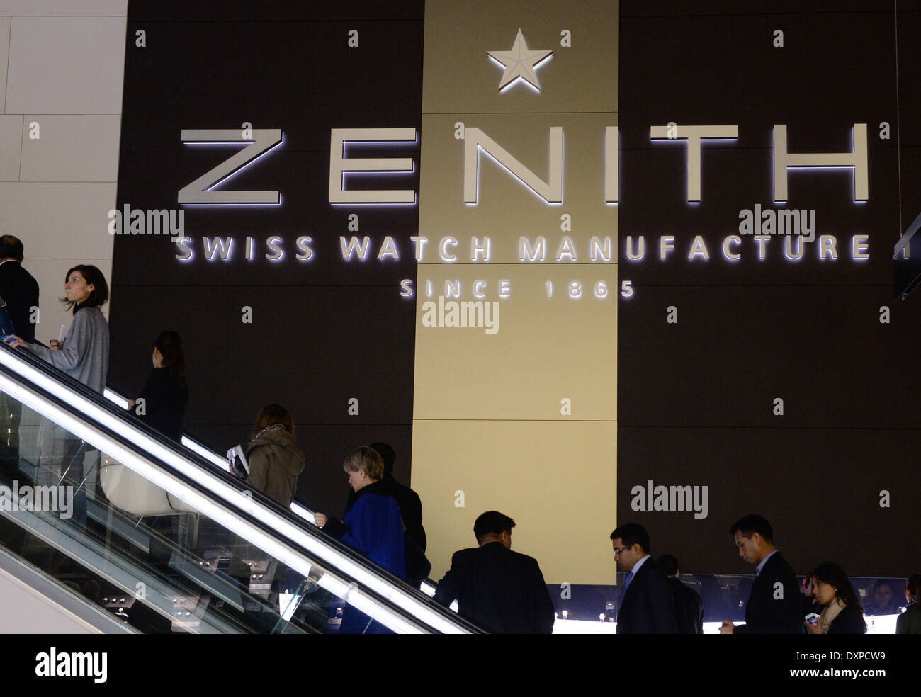 Basel, Schweiz. 28. März 2014. Besucher fahren auf einer Rolltreppe hinter dem Stand der Schweizer Uhrenmanufaktur Zenith der internationalen Uhren-und Schmuck-Messe Baselworld 2014 in Basel, Schweiz, 28. März 2014. Um das Jahr 1400 Aussteller sind Goint, die weltweit größte Messe für Uhren und Uhren, läuft vom 27. März bis 3. April 2014 zu besuchen. Foto: Patrick Seeger/Dpa/Alamy Live News Stockfoto