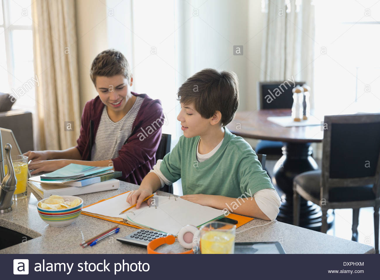 Geschwister an Hausaufgaben arbeiten Stockfoto