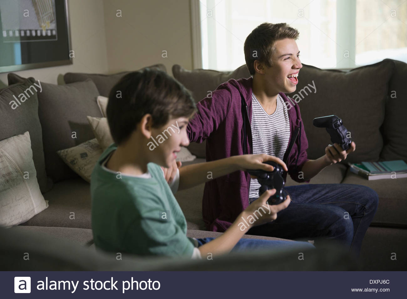Aufgeregt Brüder spielen von Videospielen auf sofa Stockfoto