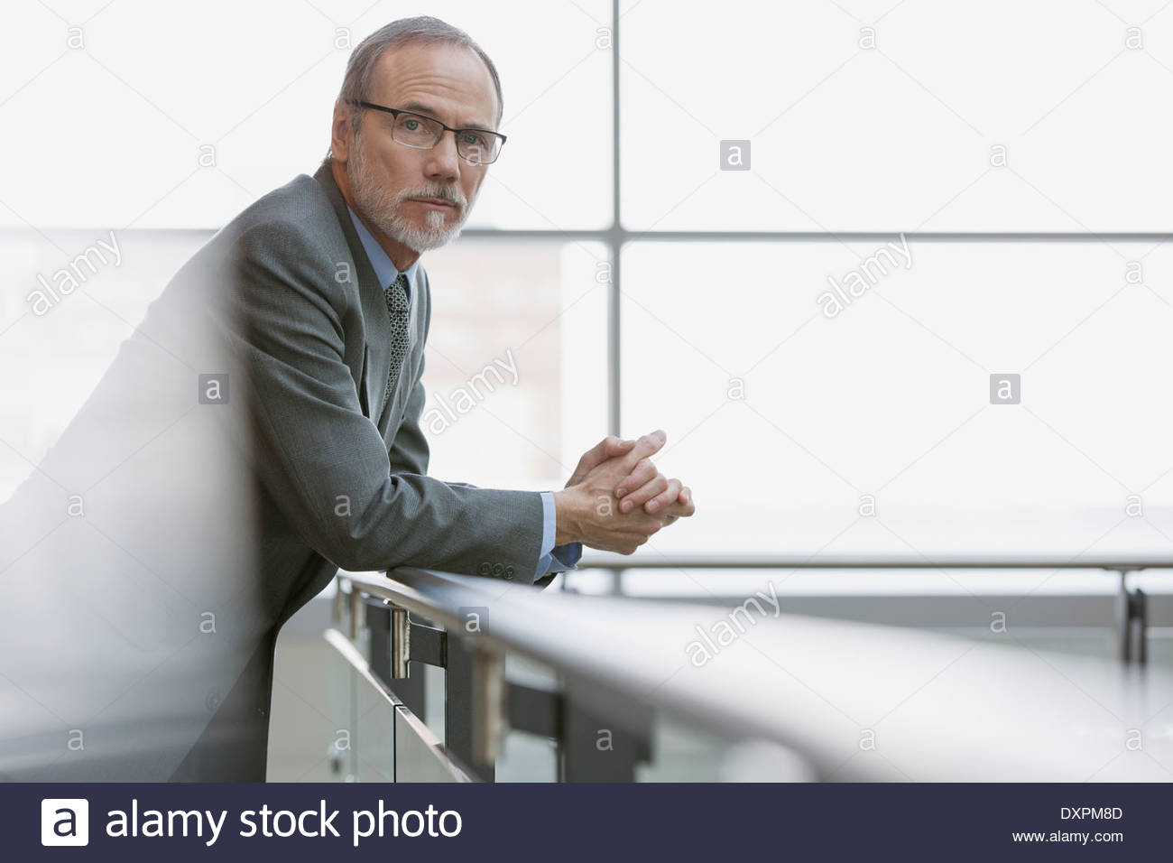 Porträt von zuversichtlich Geschäftsmann stützte sich auf Geländer Stockfoto
