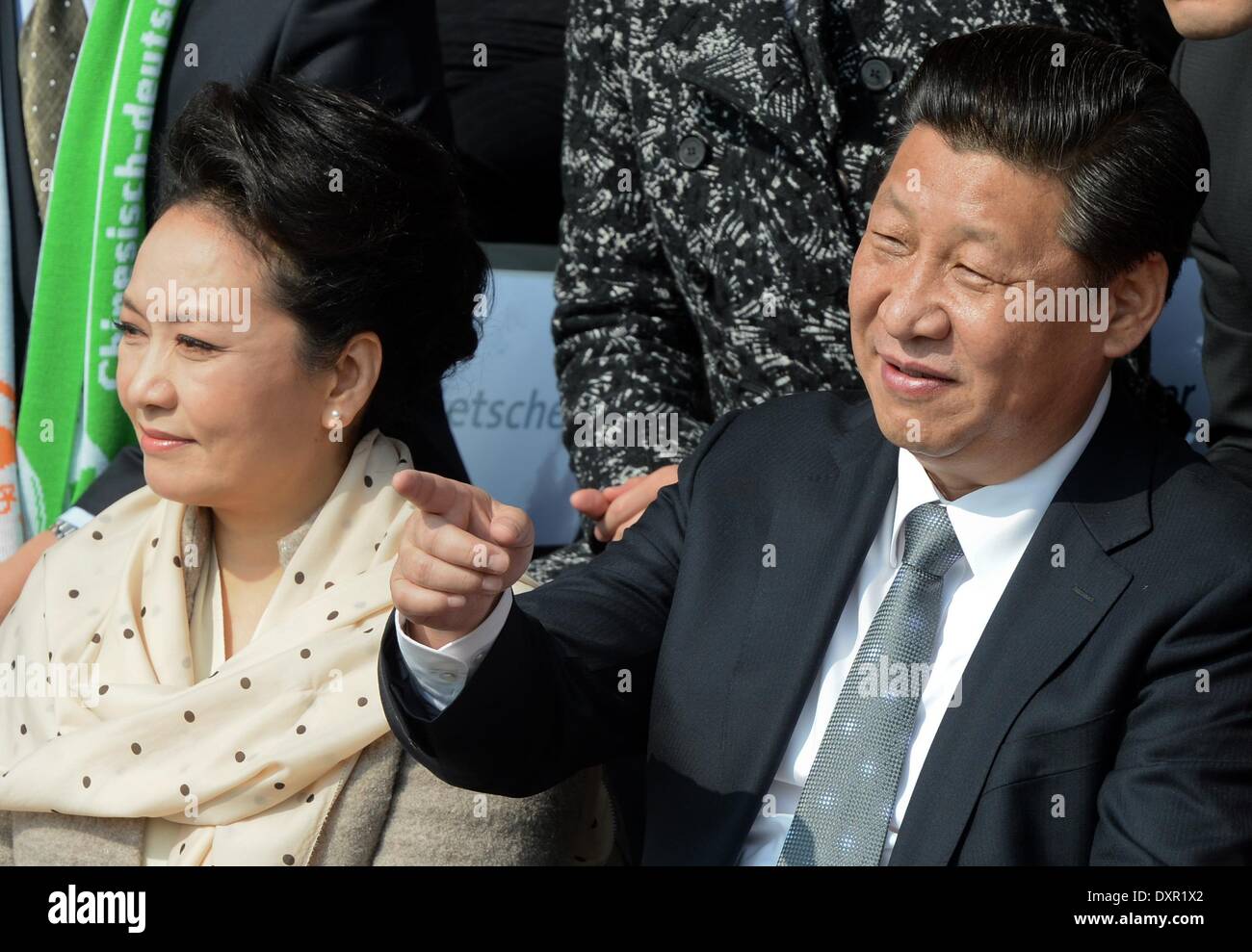 Berlin, Deutschland. 29. März 2014. Der chinesische Präsident und Generalsekretär der kommunistischen Partei Chinas, Xi Jinping (R) und seine Frau Peng Liyuan besuchen ein Freundschaftsspiel zwischen einer chinesische Jugend-Mannschaft und eine Jugend-Auswahl des Fußball-Bundesligisten VFL Wolfsburg mit einem T-shirt von Wolfsburg Bundesliga-Spieler im Olympiapark in Berlin, Deutschland, 29. März 2014 unterzeichnet. Es ist des ersten Staatsbesuchs in Deutschland von einem chinesischen Präsidenten seit acht Jahren. Foto: SOEREN STACHE/DPA/Alamy Live-Nachrichten Stockfoto