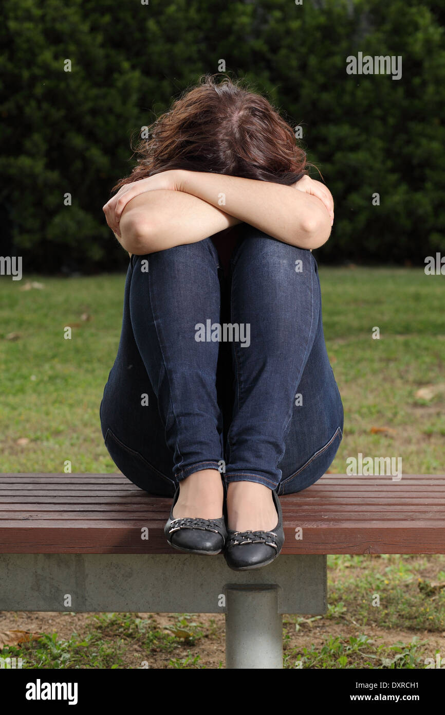 Vorderansicht eines Teenagers einsam depressiv und Traurigkeit in einem park Stockfoto