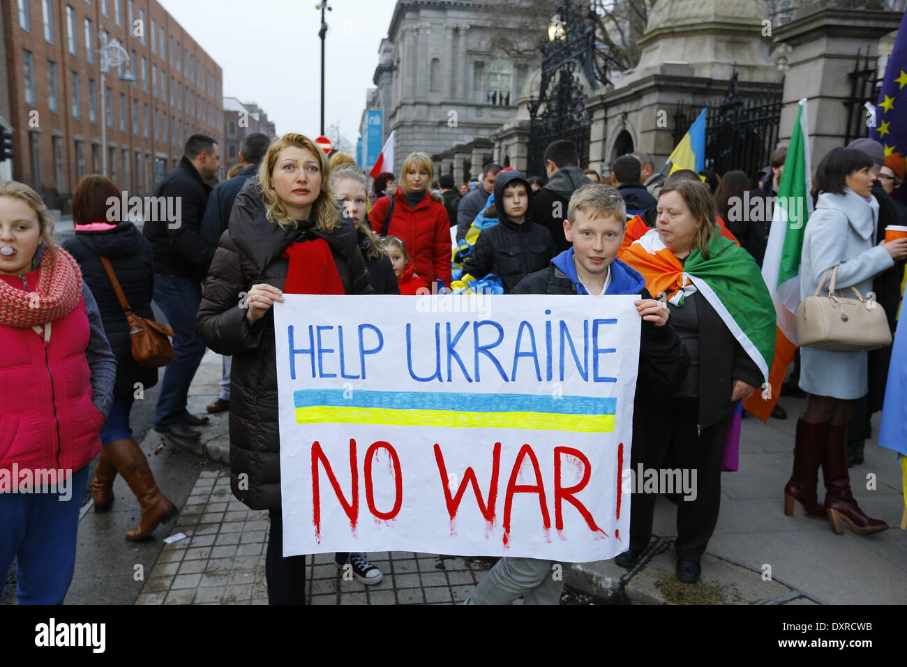 Dublin, Irland. 29. März 2014. Demonstranten stehen in Unterstützung mit dem ukrainischen Volk außerhalb der Dail. Sie halten eine Fahne, die "Helfen, Ukraine - kein Krieg" liest. Ukrainer und Iren sowie Anhänger aus anderen Ländern versammelten Dail (Irisches Parlament) in Unterstützung mit den Menschen und Demokratie in der Ukraine und gegen die Besetzung der autonomen Republik der Krim durch Russland. Bildnachweis: Michael Debets/Alamy Live-Nachrichten Stockfoto