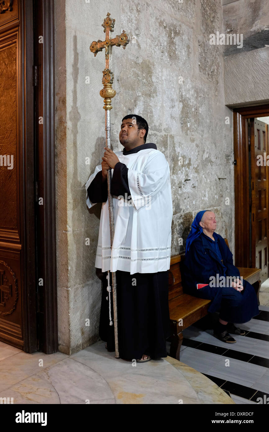 Ein Franziskanerpater hält ein Kreuz, wie er an einer Messe in der Kapelle von Mary Magdalene in der Kirche des heiligen Sepulchre alte Stadt Ost-Jerusalem Israel teilnimmt Stockfoto