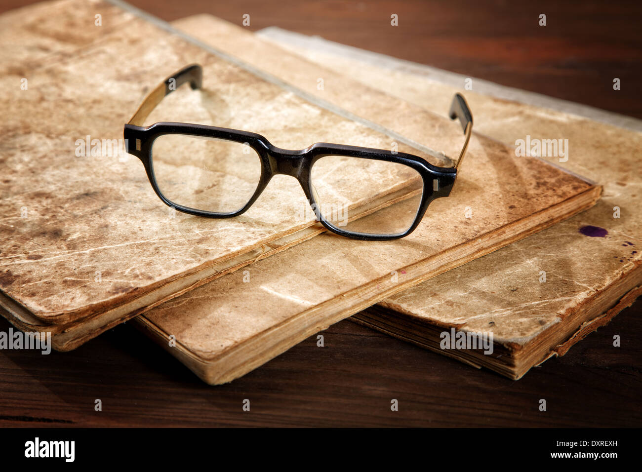 Alte Hefte und Gläser auf einem Holztisch Stockfoto