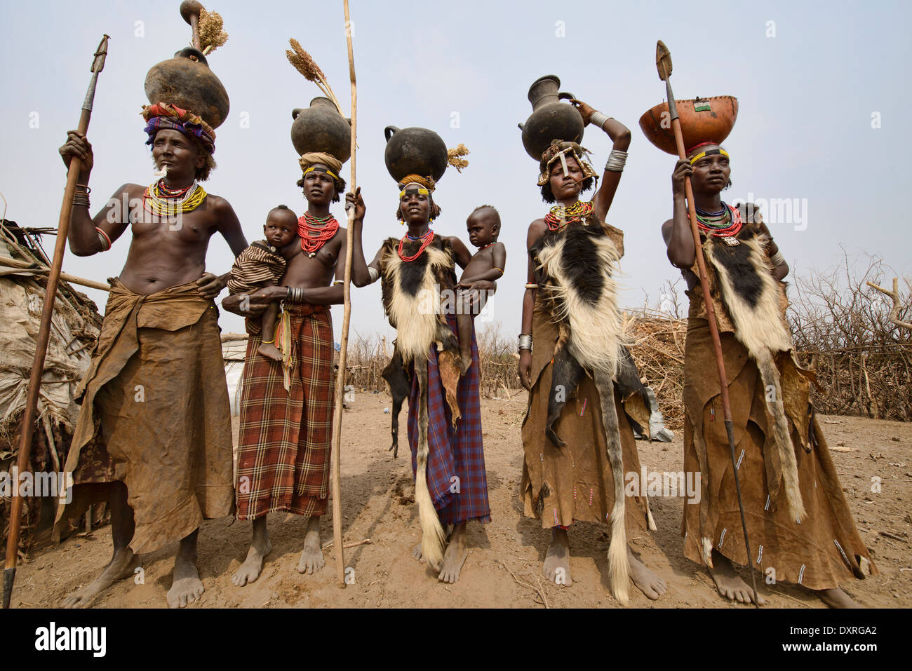 Dassanech Frauen mit Hyäne Fell Schalen und Krüge auf dem Kopf im unteren Omo-Tal von Äthiopien Stockfoto