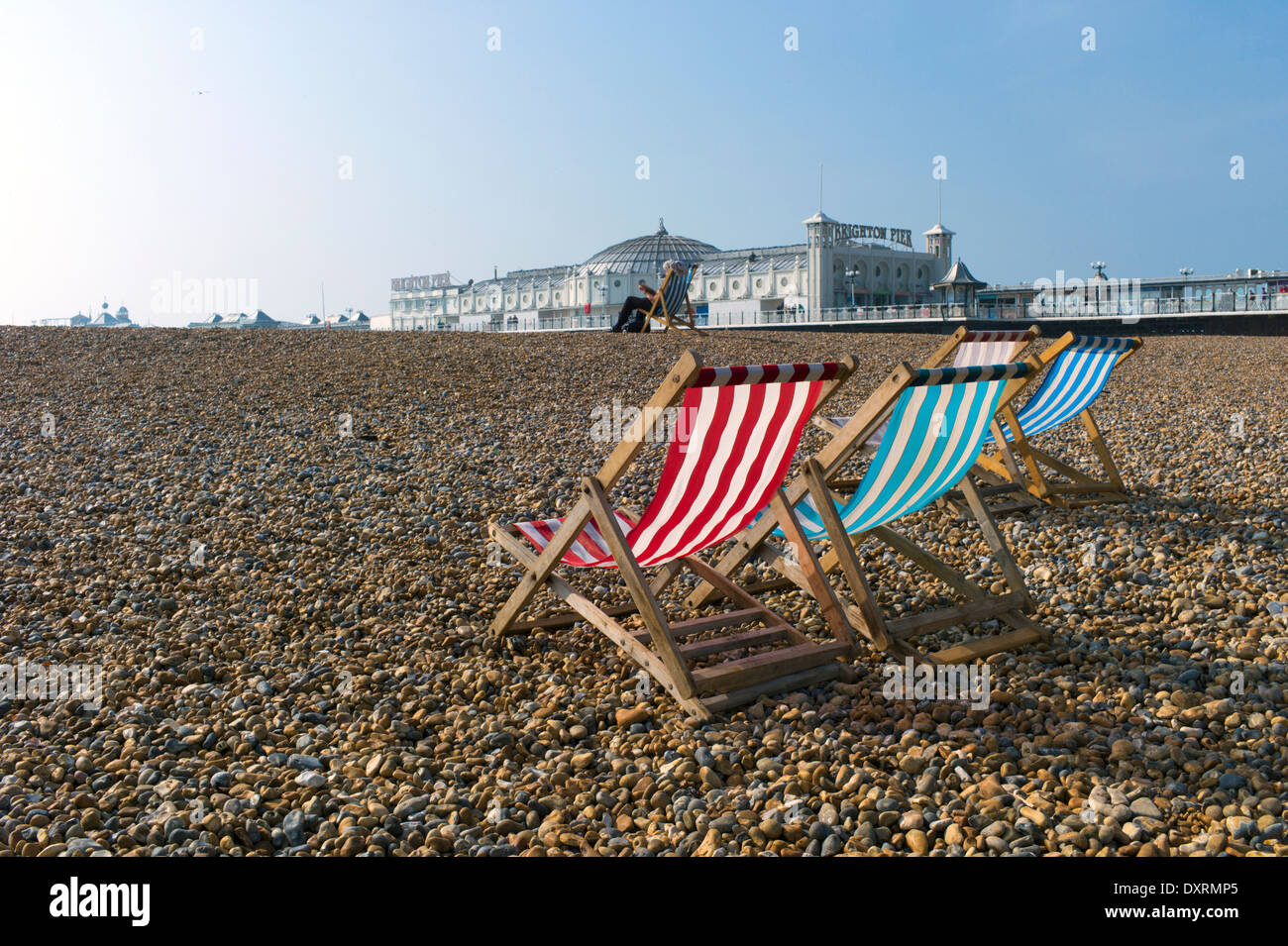 Liegestühle vor Brighton Pier am Strand Stockfoto