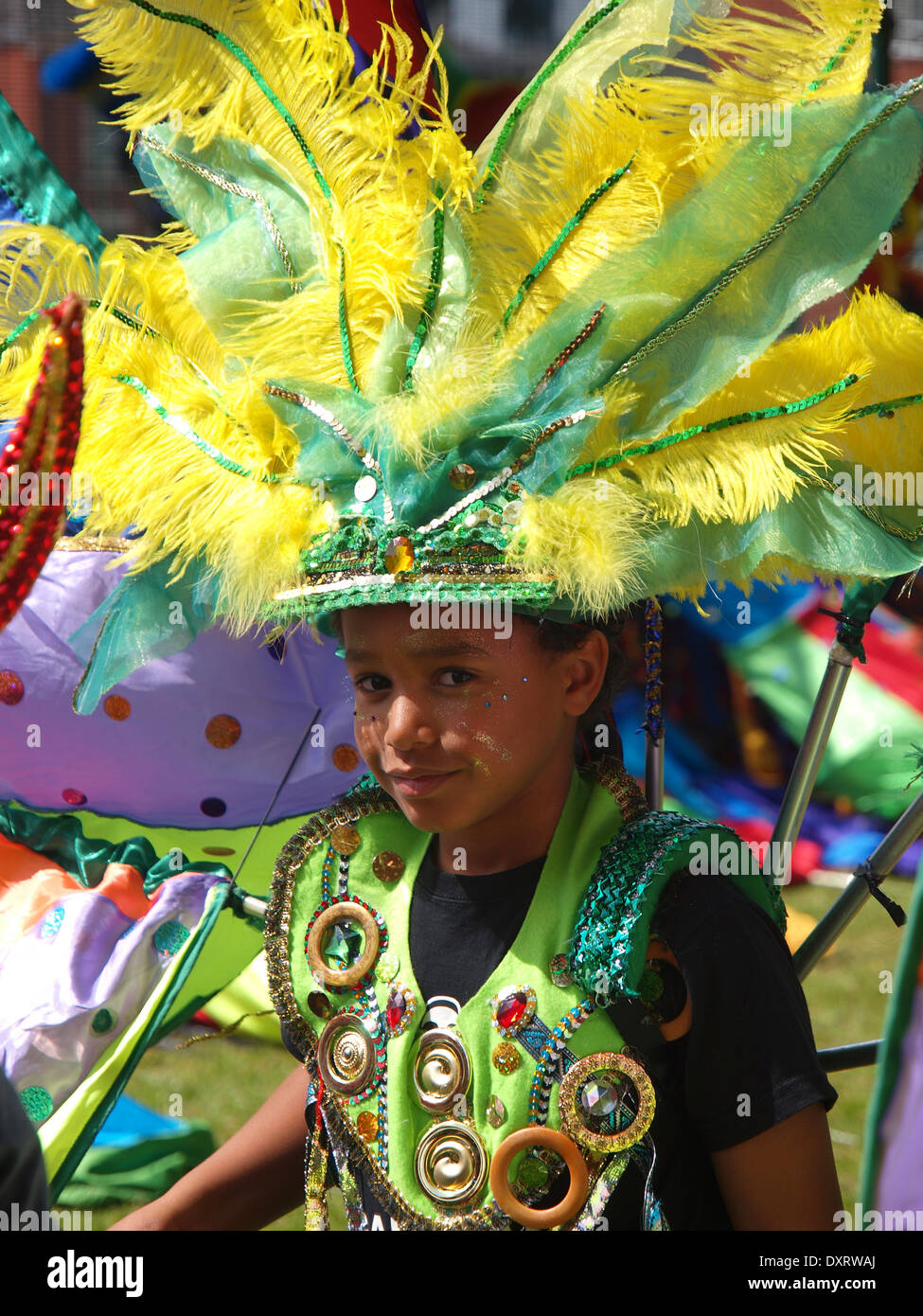 Jungen tragen Federn und Kostüm wartet seinerseits zum Jahresbeginn einen karibischen Karneval, an dem Spaß teilhaben. Stockfoto