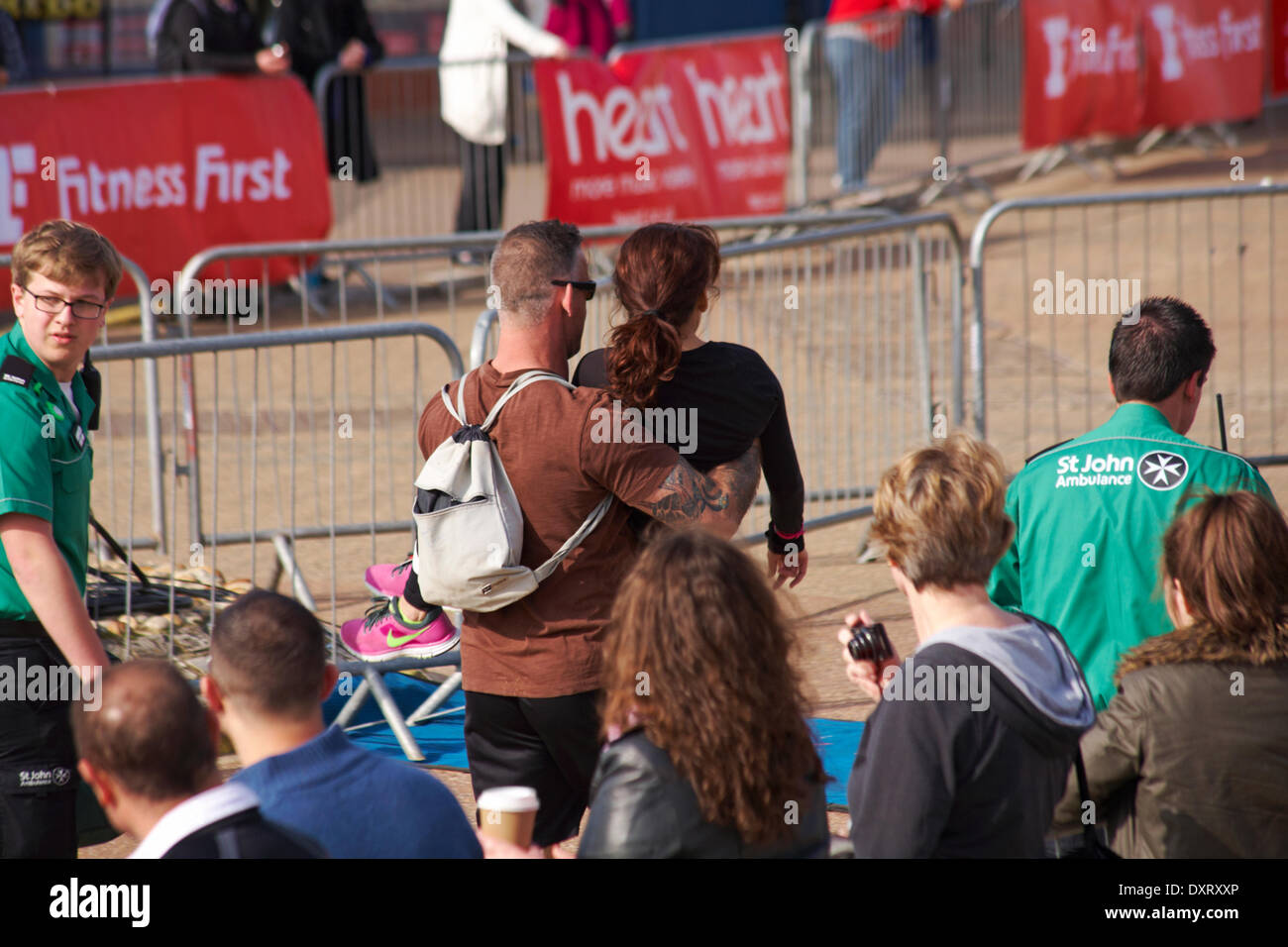 Bournemouth, UK 30. März 2014. Warme sonnige Wetter und mehr als 3000 beteiligen sich an der Bournemouth Bay Run bietet die Möglichkeit, ein Halbmarathon, 10 km Lauf, 5 k Run und 1 k Familie Fun Run Bournemouths Meer entlang. Die Teilnehmer laufen neben der Ärmelkanal-Küste, wichtige Mittel für die British Heart Foundation Charity zur Bekämpfung von Herz-Kreislauferkrankungen zu erhöhen. Frau wird durchgeführt, da fast Credit bricht: Carolyn Jenkins/Alamy Live News Stockfoto