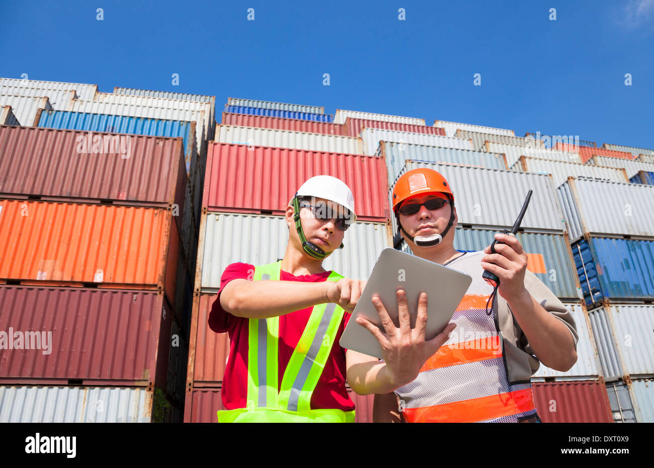 zwei Arbeiter mit Tablet und stehen vor dem Stapel von Containern Stockfoto