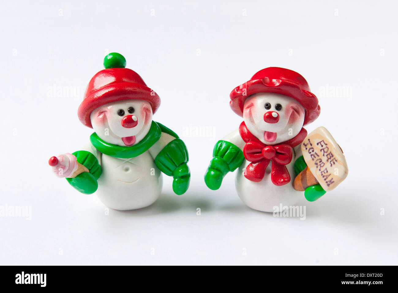 Zwei niedliche Ton Schneemänner tragen rote & grünen Urlaub Kleider, verlosen kostenlos Eis im Winter. Stockfoto
