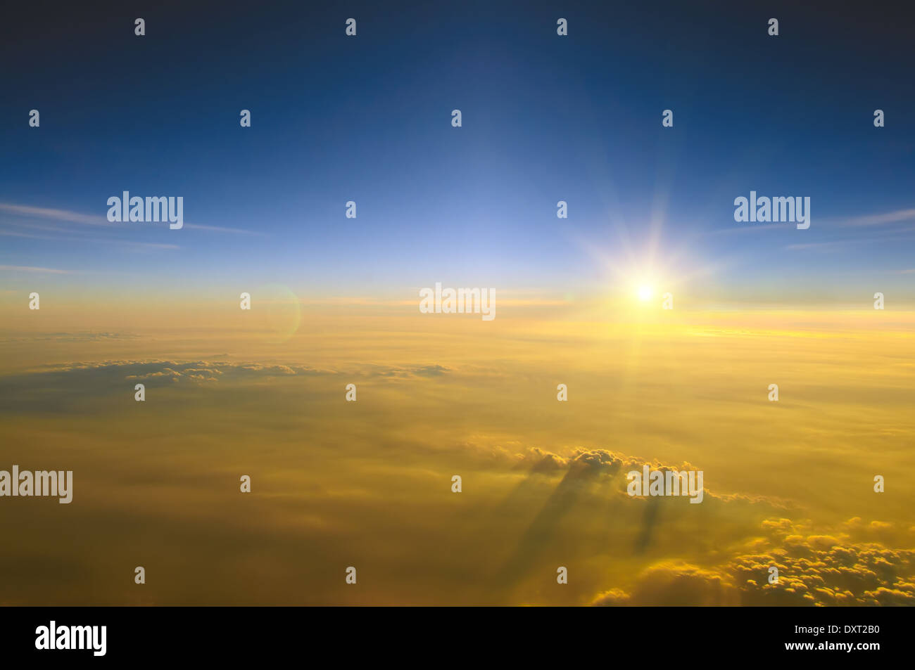 Spektakuläre Aussicht auf den Sonnenuntergang über den Wolken aus Flugzeugfenster Stockfoto