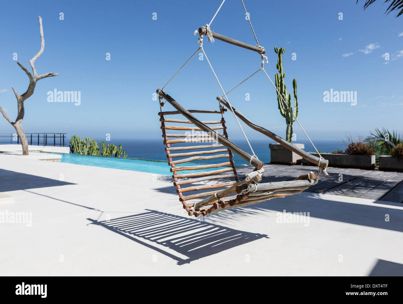 Hängenden hölzernen Stuhl auf Luxus-Terrasse mit Blick auf Meer Stockfoto