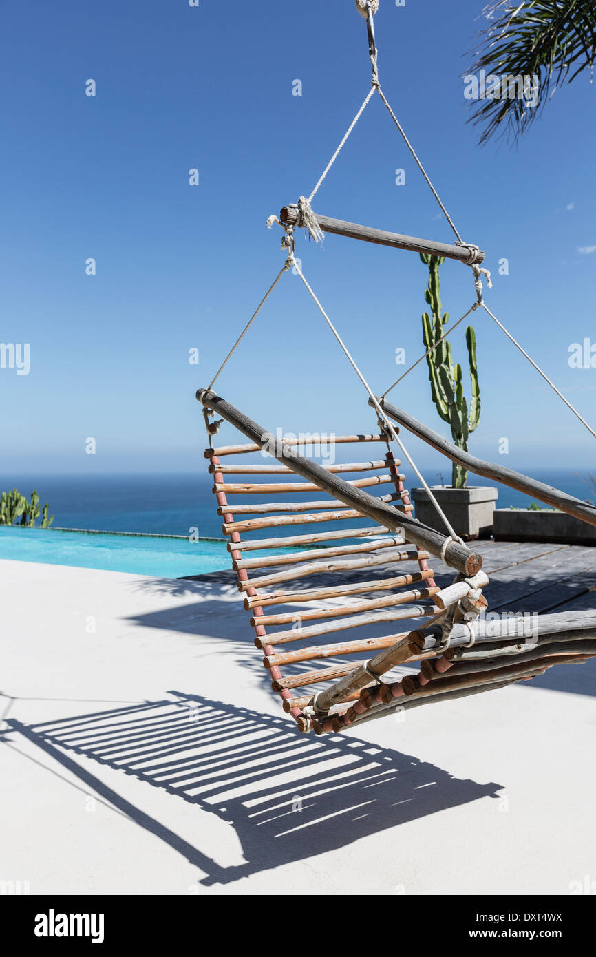 Hängenden hölzernen Stuhl auf Luxus-Terrasse mit Blick auf Meer Stockfoto