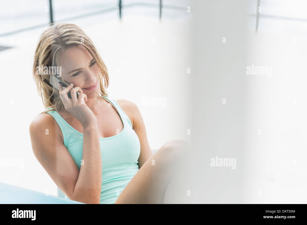 Lächelnde Frau am Handy auf Terrasse Stockfoto