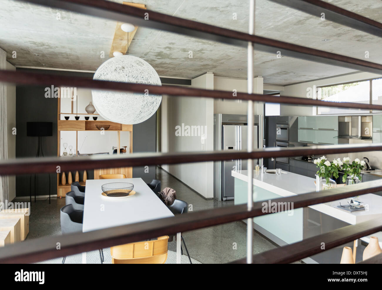 Blick auf moderne Esszimmer und Küche durch Holzleisten Stockfoto