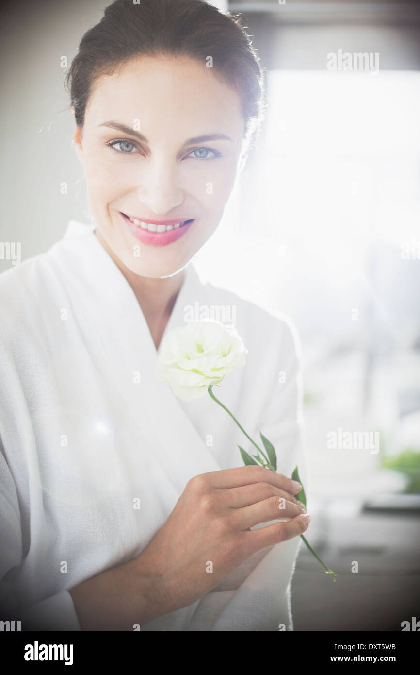Porträt der lächelnde Frau im Bademantel mit weißer rose Stockfoto