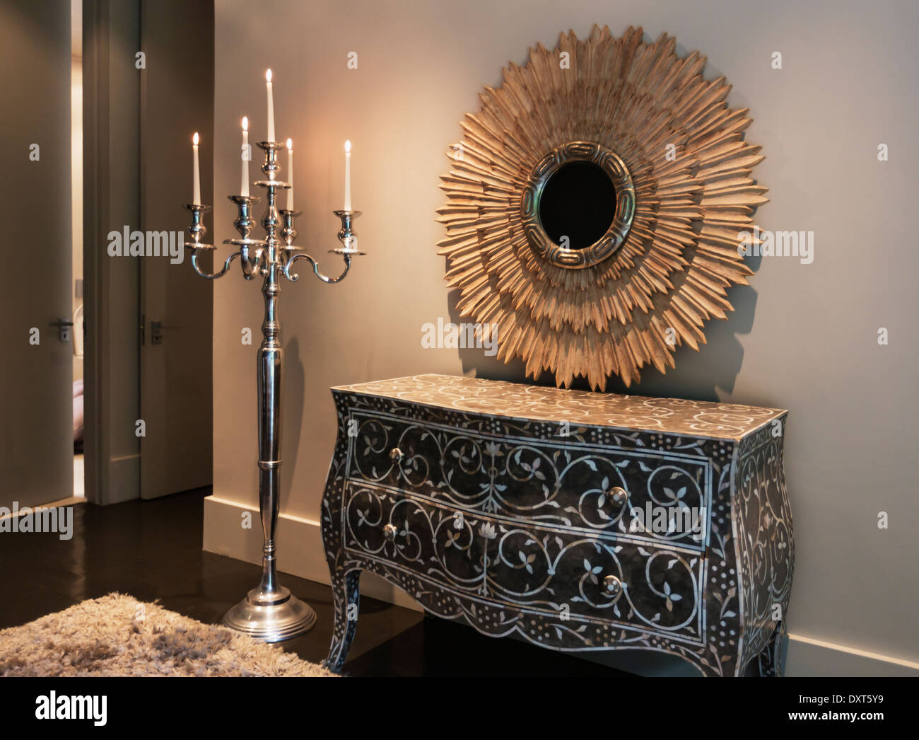 Elegante Kommode, Spiegel und Kerzenleuchter in Luxus Schlafzimmer Stockfoto