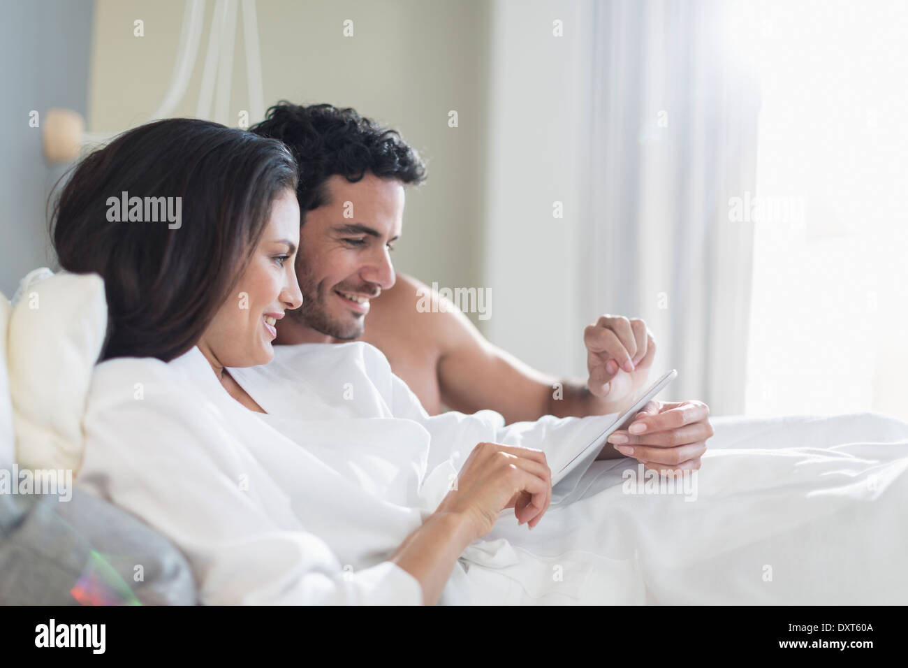 Paar mit digital-Tablette im Bett Stockfoto