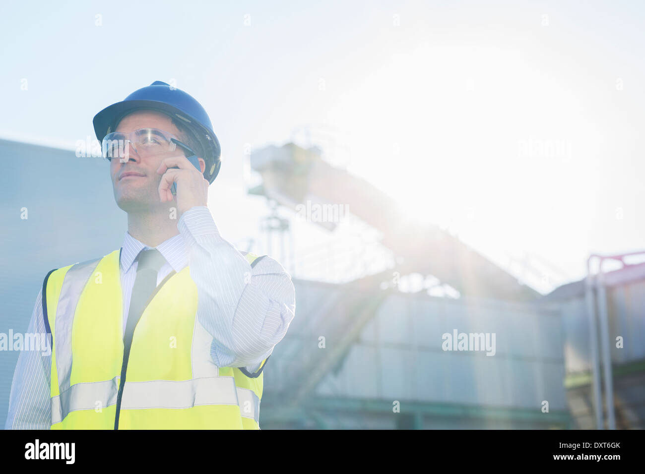 Arbeiter reden über Handy am Getreidespeicher Stockfoto