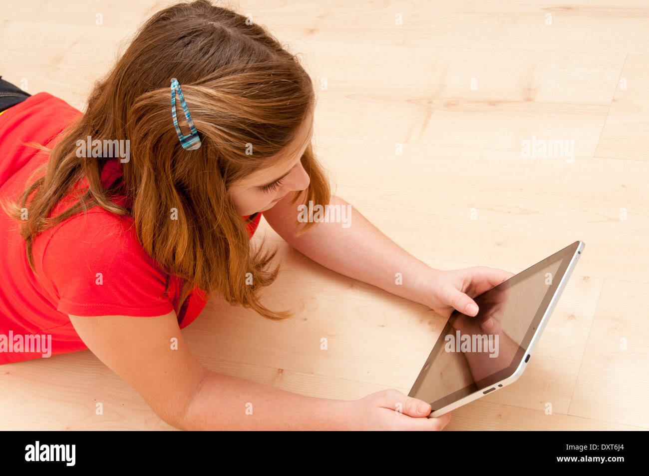 Mädchen 10 oder 11 Jahre alt, Lesen auf einem Tablet Stockfoto