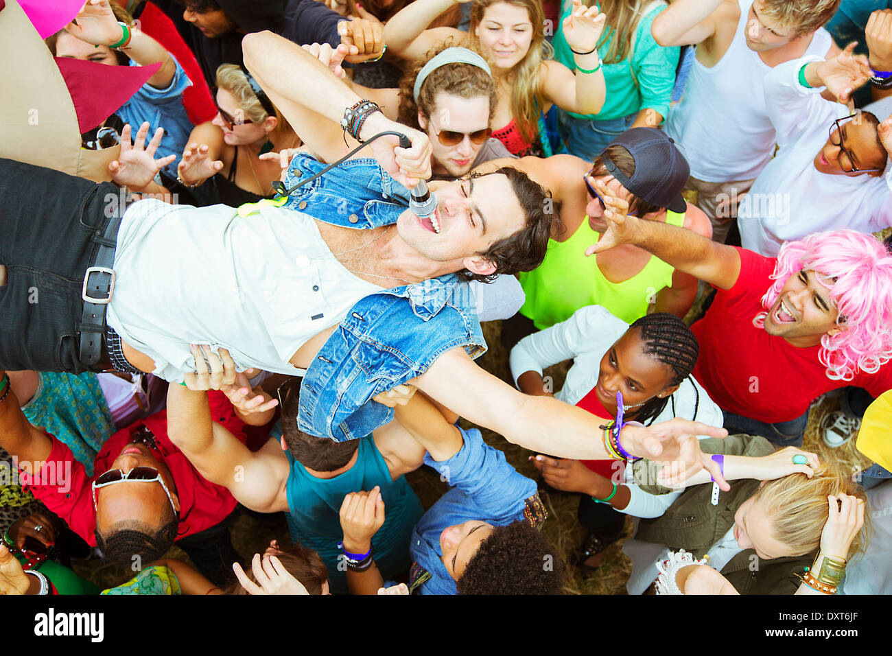 Performer mit Mikrofon Crowdsurfing beim Musikfestival Stockfoto